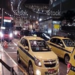 Scene Of Advertisement Sign, People Waiting, Boarding Taxi, Taxi Driver Waiting For Customer And More In The Evening At Rio De Janeiro Galeao International Airport Taxi Stand In Brazil South America